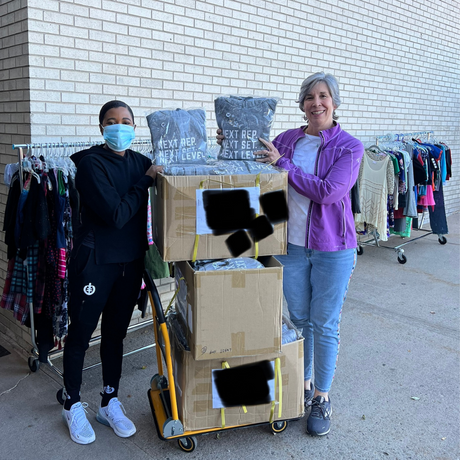 (Click to Read) A photo of ICONI CEO and Clothes to Kids of Denver Member accepting sweatshirt donations from ICONI