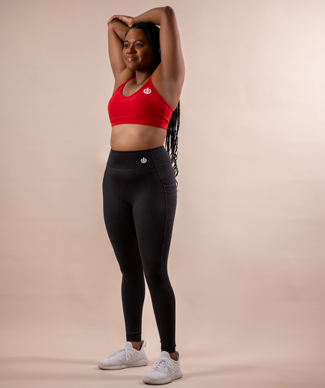 Woman posed wearing Embrace Legging and Red Low Impact V-Neck Sports Bra. 