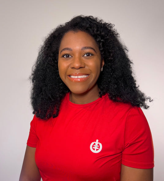 Headshot of ICONI CEO Angel Johnson smiling in a red ICONI t-shirt